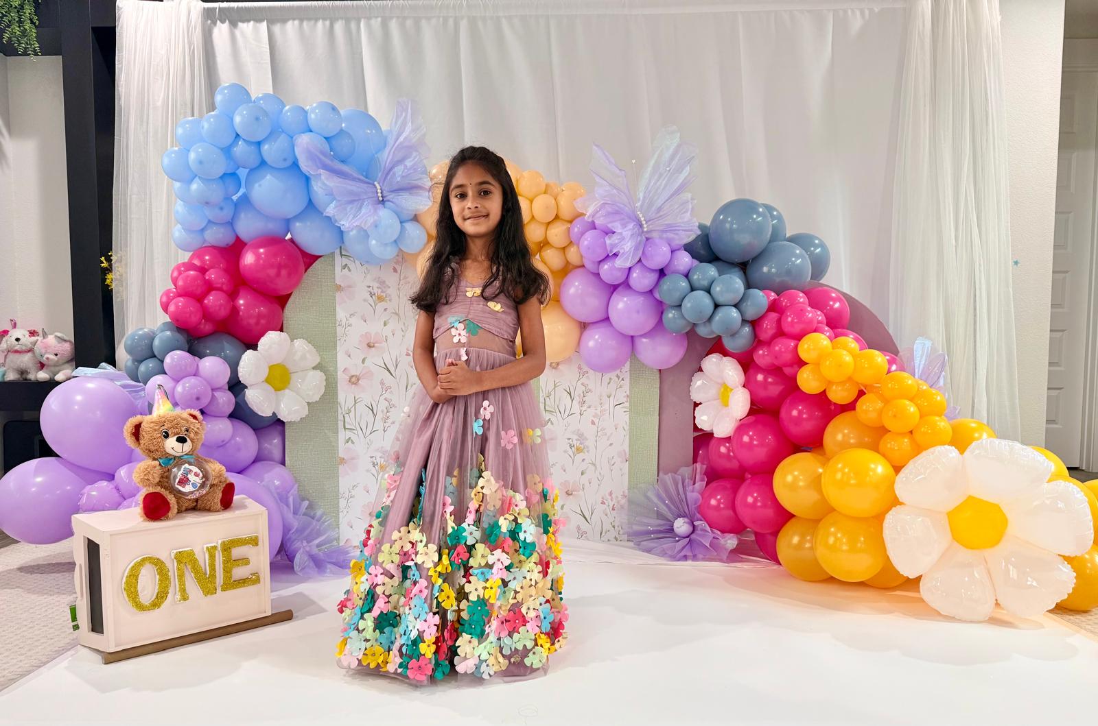 Mauve girls gown finished with colorful floral appliqué